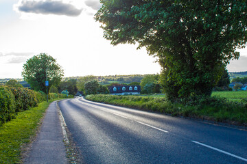 asphalted road in the village at sunset, beautiful blue sky at sunset, plants and trees