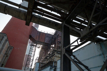 A massive gas exhaust system at a high-capacity thermal power plant. Towering red-and-white chimneys exceed 150 meters in height, facilitating emissions management and industrial air circulation.