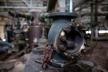Disassembled industrial valve used for maintenance and repair. The metal housing, bolts, and internal components are laid out on a workbench, showing detailed mechanical parts.