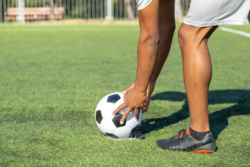Soccer player placing ball on artificial turf field