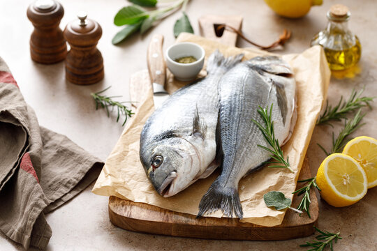 Fresh raw sea bream fish or dorado fish with lemon and herbs
