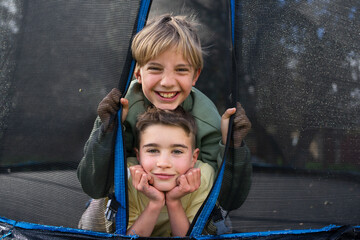 Two happy brothers having fun and smiling on a trampoline