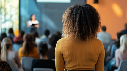 Business Presentation Perspective: An audience member attentively observes a business presentation, offering a unique angle on the event, the speaker in the distance, and the collective engagement.