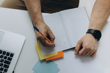 Close up, business man using mobile smart phone and and makes notes in a notebook. makes an...