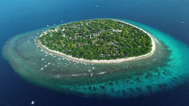 Aerial around view of tropical island Balicasag surrounded by turquoise waters and coral reefs, Philippines, 4k