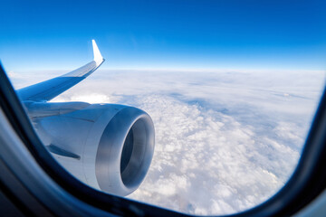 Airplane engine and wing seen from the window. Flying in an airplane above the clouds.
