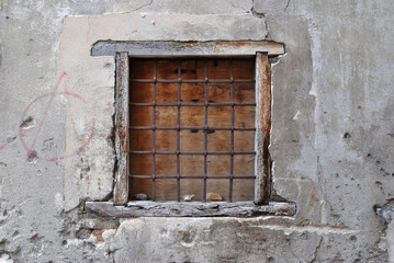 Ancient Barred Window in Old Stone Wall in Close Up 