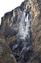 A waterfall flowing through a narrow crevice between rocks in Shahdag in the Caucasus Mountains