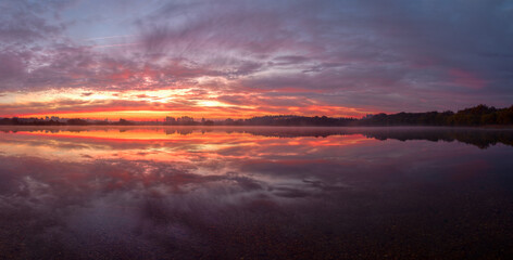 The still waters of a lagoon reflect a beautiful sunrise