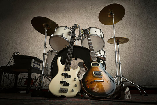 Rock Band, solo guitar, bass, drums in dark light ready for the gig. Rehearsal base. Recording studio. Rock and roll concept