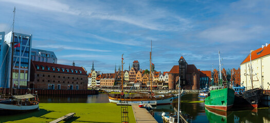 Scenic view of a marina on a sunny day, featuring a variety of yachts docked along the pier in Gdansk, Poland. Picturesque waterfront scene.