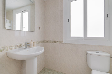 Bright bathroom corner with pedestal sink white ceramic tiles and wide frosted window