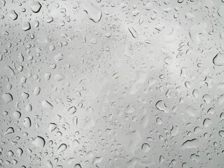 Water drops on glass on a gray background