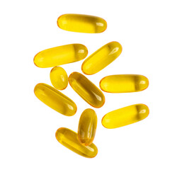 Bright yellow capsules scattered transparency background, showcasing their smooth texture and glossy finish. These capsules are often associated with health supplements and vitamins, conveying