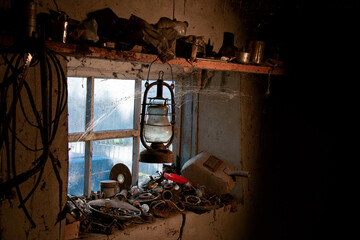 Auto mechanic's workshop. Light in the window, age-old cobwebs. Tools on the windowsill. Kerosene lamp, country. Necessary items in the everyday life of an auto mechanic.
