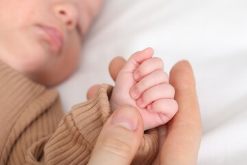 Mother with her little baby on bed indoors, closeup