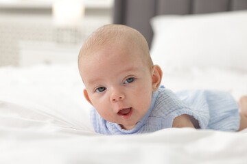 Cute little baby on bed at home