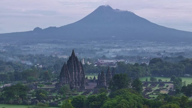Breathtaking aerial footage captures ancient temple of Prambanan with mountain background. Prambanan Temple and Merapi Volcano, Indonesia.
