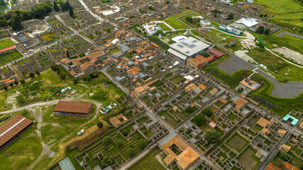 Fototapeta premium Aerial view of the archaeological park of Pompeii, located in the province of Naples, Campania, Italy. It is famous for the remains and ruins of the palaces and houses of an ancient Roman city.