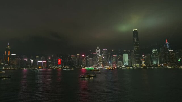 Light show in Hong Kong at night. Victoria Harbour with boats and skyscrapers, Hong Kong Central, time lapse, 4k