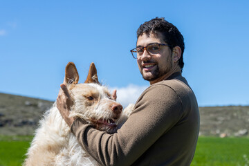 Veterinarian embracing a hunting dog in a green field