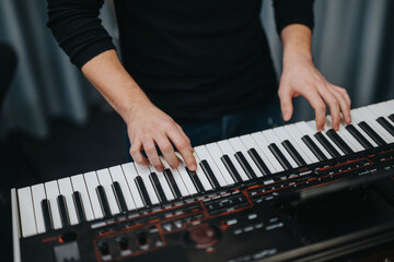 Obraz premium Photograph showcasing a musician's hands performing on a modern synthesizer keyboard, emphasizing creativity, music production, and passion for electronic music creation.