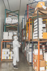 Asian warehouse worker inspect box of products on warehouse shelves