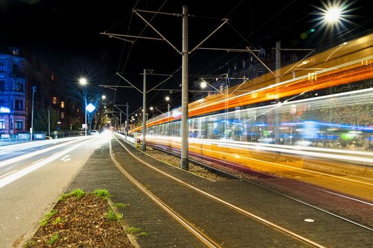 Tram light trails in city nightscape.