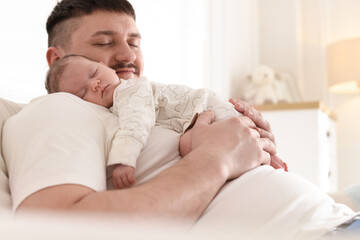 Father with his cute newborn baby indoors