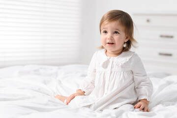 Fototapeta premium Cute little baby girl on bed at home. Space for text
