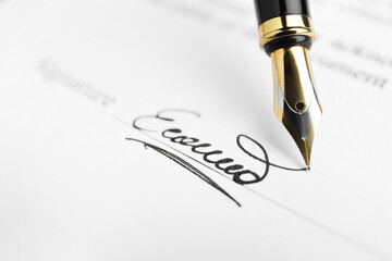 Fountain pen leaving signature on contract, closeup