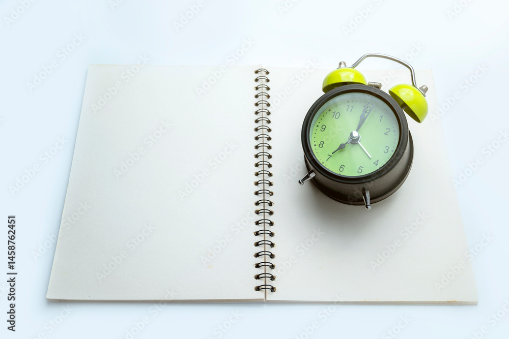 Poster green alarm clock and notebook on white background. empty area for mockup or copy space. concept of 