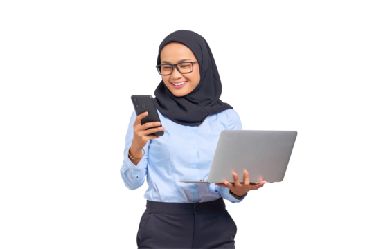 Portrait of smiling young Asian woman holding a laptop and looking at mobile phone screen isolated on transparent background
