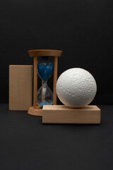 Still life with wooden blocks, hourglass and a a plastic foam ball	