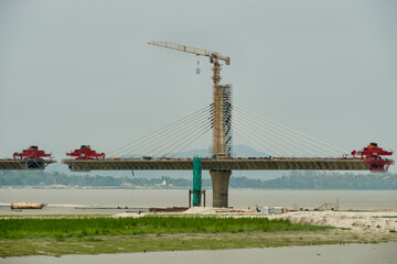 Fototapeta premium Launching gantries at the ends of bridge segments of a cable stayed river bridge under construction