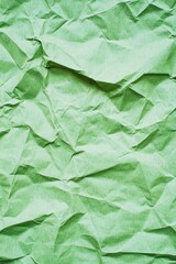 Crumpled green paper creates an interesting texture suitable for design and crafts projects in natural light