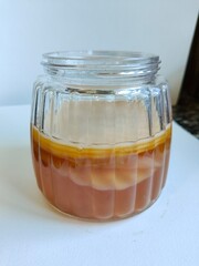 Kombucha tea drink in glass jar. SCOBY culture. Fermented foods, prebiotic, probiotic, healthy food concept. Wellness lifestyle.