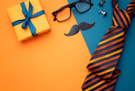 Father's day composition, flat lay objects,nobody. Gift box glasses tie mustache genleman accessories top view.