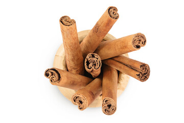 Cinnamon sticks in wooden bowl isolated on white background with full depth of field. Top view....