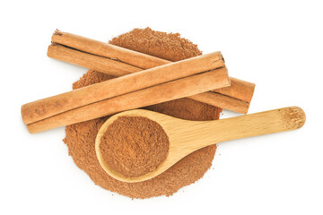 Cinnamon sticks with powder in wooden spoon isolated on white background. Top view. Flat lay.