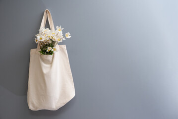 Wildflowers in a reusable fabric vintage bag on a gray background. Eco-friendly and natural. Plastic-free and waste-free.