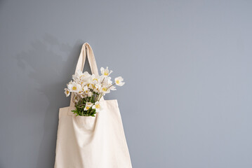 Wildflowers in a reusable fabric vintage bag on a gray background. Eco-friendly and natural. Plastic-free and waste-free.