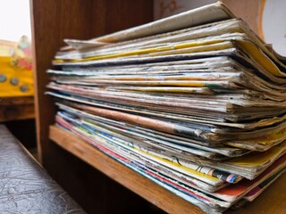 Closeup of a messy pile of old magazines with bending pages. the old paper texture of many old...