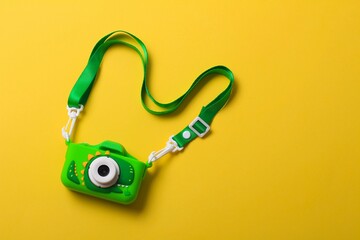 Colorful toy camera rests on a bright yellow background, capturing playful moments in any child's...