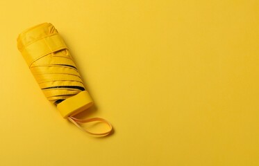 Bright yellow umbrella on yellow background.