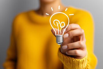 Person holding glowing light bulb icon above head representing a bright idea. Soft studio lighting creates a minimalist atmosphere. Concept of creativity, innovation, and business strategy