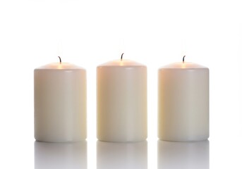 Three ivory pillar candles with extinguished wicks arranged in a row on a reflective surface against white