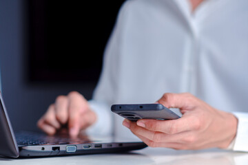 Person Using Laptop and Smartphone for Modern Communication Task