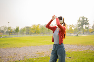 Happy Asian woman listening to music outdoors