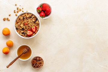 Bowl of cereal granola with strawberry and honey for breakfast, top view